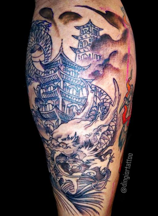 Чорне татуювання пагоди та дракона біля храма